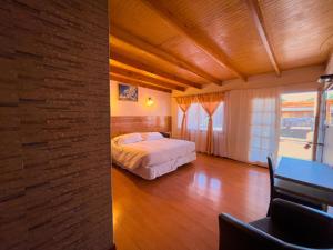 a bedroom with a bed and a table in a room at Ittai Hotel in San Pedro de Atacama