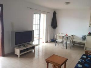 een woonkamer met een flatscreen-tv en een tafel bij 124 PORIS DE ABONA Holiday Home by Sunkeyrents in Santa Cruz de Tenerife