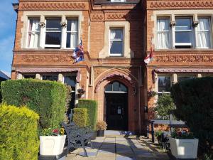 Un edificio con dos banderas delante. en The Lismore Hotel, en Banbury