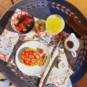 un tavolo con un piatto di cibo e una ciotola di fragole di B&b Peonia orgosolo a Orgosolo
