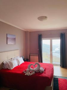 Un dormitorio con una cama roja con dos cisnes. en Casa Vale do Douro, en Mesão Frio