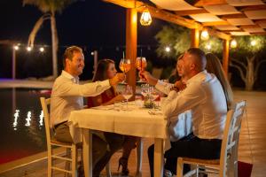 un grupo de personas sentadas alrededor de una mesa bebiendo vino en Sa Iba Resort, en Tertenìa