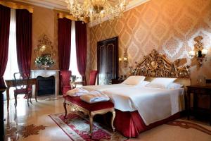 a bedroom with a large bed and a chandelier at Hotel Ai Reali - Small Luxury Hotels of the World in Venice