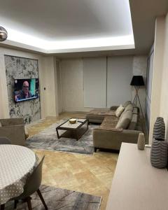 sala de estar con 2 sofás y TV de pantalla plana en Apartman Budva sa garaznim mjestom, en Budva