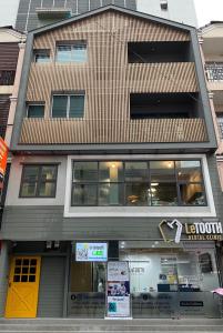 北革Grasshopper Bed and Cafe的一条城市街道上一座有黄色门的建筑