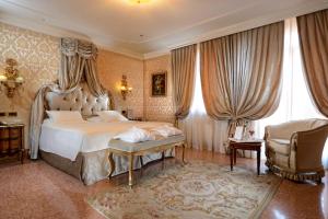 - une chambre avec un grand lit et une chaise dans l'établissement Hotel Ai Reali - Small Luxury Hotels of the World, à Venise