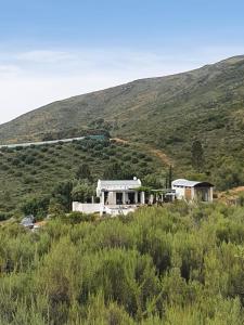 uma casa numa colina com um comboio ao fundo em Kleinkloof Farm em Piketberg