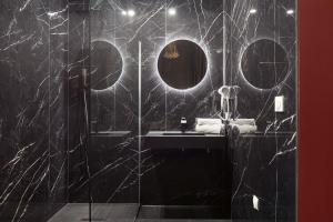 a black bathroom with a sink and a mirror at Legend Majestic Superbe Love Room - Jacuzzi - Champagne - Romantisme - parking privé in Mâcon