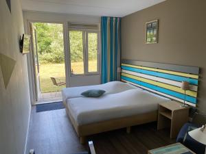 a bedroom with a bed with a colorful striped headboard at Hotel DoniaState in Oost-Vlieland