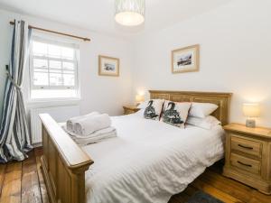 1 dormitorio con cama y ventana en The Yellow House, 13 King Street, en Dawlish