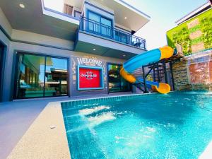 a pool with a slide in front of a house at Lounge in Loft HuaHin Pool Villa บ้านพักในหัวหิน in Ban Wang Bot