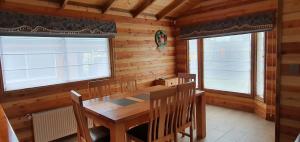 a dining room with a wooden table and chairs at Cabañas, canchas de pádel, básquet, voley, juegos infantiles y más in Villarrica