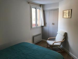 a bedroom with a bed and a chair and a window at Appartement Montgenèvre, 3 pièces, 6 personnes - FR-1-445-6 in Montgenèvre