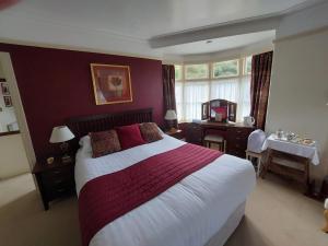 um quarto de hotel com uma cama grande e uma janela em The Denes em Lynton