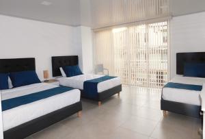 a bedroom with two beds and a large window at Hotel Monarka-Edificio in Popayan