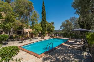 una piscina en un patio con sombrilla en Agroturismo Son Penyaflor en Alaró