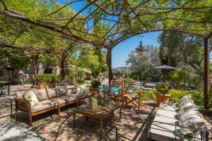 une terrasse avec des canapés et des tables sous un arbre dans l'établissement Agroturismo Son Penyaflor, à Alaró