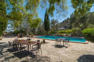 eine Terrasse mit Tischen und Stühlen neben einem Pool in der Unterkunft Agroturismo Son Penyaflor in Alaró