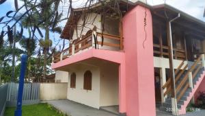 un bâtiment rose avec un escalier. dans l'établissement Residencial Lumar, à Itapoá