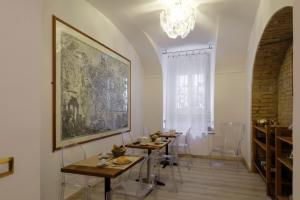 una sala da pranzo con due tavoli e un dipinto sul muro di DCBoutiqueHotel a Roma