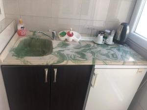 a kitchen counter with a sink in a room at Taf's Small House in Pristina