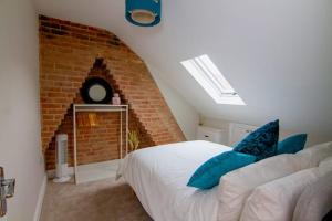a bedroom with a white bed and a brick wall at City View Apartment in Salisbury