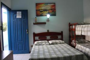 Un pat sau paturi într-o cameră la Pousada Flor de Aurora Bertioga