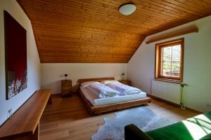 een slaapkamer met een bed en een houten plafond bij Frein Chalets - Wildalm in Frein