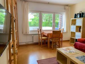 a living room with a table and chairs and a window at Ferienbungalow 182 in Stahlbrode
