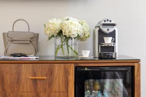 a counter with flowers and a coffee maker on it at The Queens Gate Hotel in London