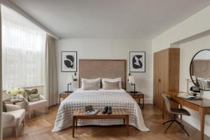 a bedroom with a bed and a desk and a chair at The Queens Gate Hotel in London