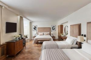a hotel room with two beds and a television at The Queens Gate Hotel in London
