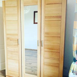 a wooden cabinet with a glass door in a room at Ferienwohnung Heiligenhagen in Satow