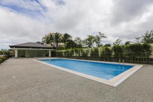 a swimming pool in front of a house at Hotel Casiana Tagaytay Managed by HII in Tagaytay