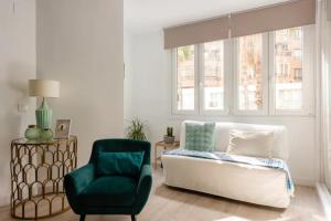 a living room with a green chair and a couch at NUEVO APARTAMENTO LUJO PLAYA MALAGUETA-CENTRO in Málaga