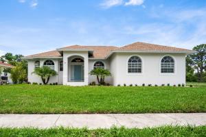 een wit huis met een groen gazon bij Tahiti House in Marco Island