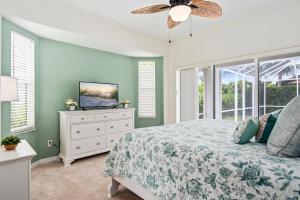 een slaapkamer met een bed en een tv op een dressoir bij Tahiti House in Marco Island +30 foto's