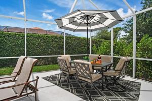 a patio with a table and chairs and an umbrella at Tahiti House in Marco Island