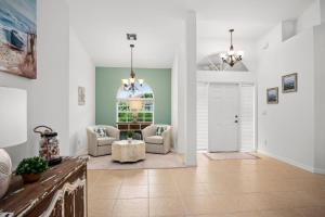 a living room with two chairs and a table at Tahiti House in Marco Island +30 photos