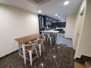 a kitchen with a table and stools in a room at PKA Residence at Taman Bentong Makmur in Bentong