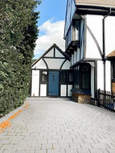 a house with a blue door and a driveway at Luxury & Spacious 2 Bed Annex with Private Garden in Potters Bar