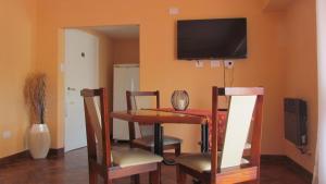 a dining room with a table and chairs and a television at Terraza La Falda in La Falda