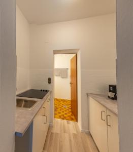 uma cozinha com armários brancos e piso em madeira em Wohhhlfühl Appartement im Zentrum Graz em Graz