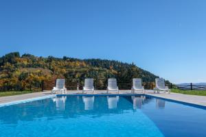 a swimming pool with chairs and a mountain in the background at Villa Sarajevo in Vareš