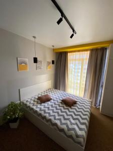 a bedroom with a bed with two pillows and a window at Belvederska apartment 2 in Ivano-Frankivsʼk