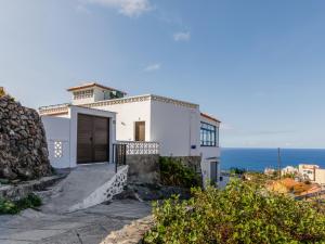 a white house with the ocean in the background at Anaga Ocean Views (A): Mountain and Beach Retreat in Santa Cruz de Tenerife