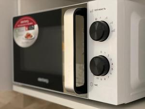 a microwave oven with two knobs on a counter at Belvederska apartment 2 in Ivano-Frankivsk