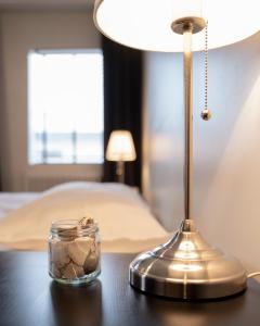 a table with a lamp and a jar of rocks on it at Fisherman Hotel Westfjords in Suðureyri