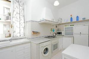 a white kitchen with a washing machine and a sink at Tirso in Rome