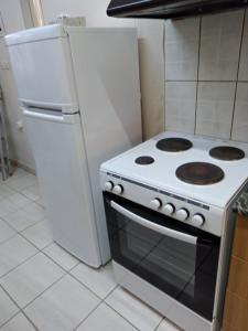 a white stove in a kitchen with a refrigerator at Cosy Studio Down Town in Kavala